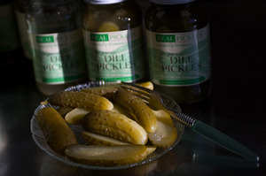 Sliced pickles from Real Pickles, in front of an array of jars