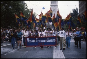 Marchers in the San Francisco Pride Parade with pride flags and banner 'Proud / Strong United 1987'