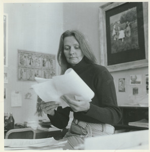 Joan P. Bean sitting indoors, reading