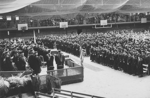 Graduates, guests and faculty stand during commencement exercises