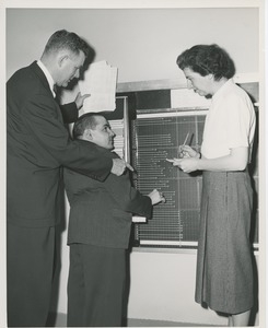 Willis C. Gorthy and an unidentifed man and woman using a chart board at an ICD field workshop