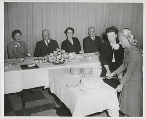 Margaret Milbank Bogert and another woman cut a cake at the Institute for the Crippled and Disabled's 35th anniversary Red Cross luncheon