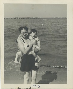 Bernice Kahn holding her song Paul at the shoreline of the beach