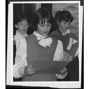 Children standing and holding up folders