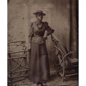 An African American woman leaning on a chair