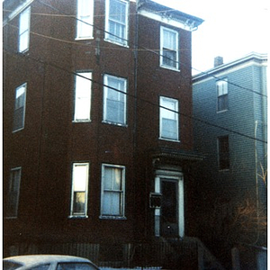 Exterior view of a three-story brick residential building in Roxbury, Mass