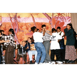 High school students dancing together on stage during a music and dance program organized by Inquilinos Boricuas en Acción's Areyto.