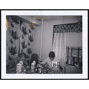 A woman and a teenage boy from the Charlestown Boys' Club eating cereal in an apartment