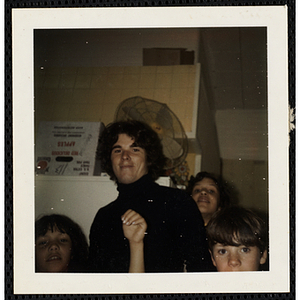 A male staffer standing with several children and looking at the camera at the South Boston Boys' Club