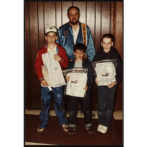 An Unidentified man and three boys showing off their Puma track pants at an open house