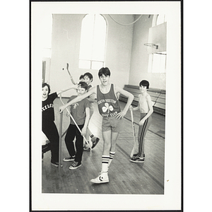 Boys with floor hockey sticks pose for a candid shot