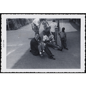 A group of seated boys listen to a man address them on Tom Sawyer Day