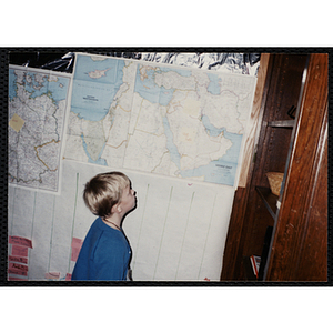 A Young boy, identified as Jack Flaherty, looking at a map of the Middle East