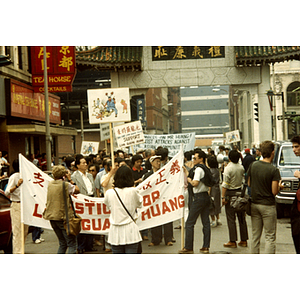 Protesters carry signs and banners at the Long Guang Huang demonstration at the Chinatown Gate in Boston