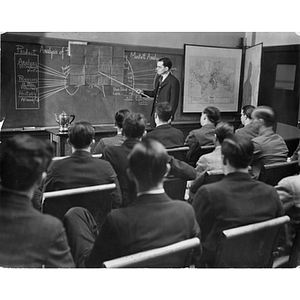 Dean Lake stands at the chalkboard in a marketing class