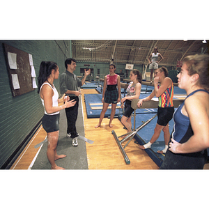 Gymnastics coach instructs the team