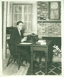 Portrait of Bruce Barton, seated at a typewriter, facing three-quarters to the left, location unknown, undated