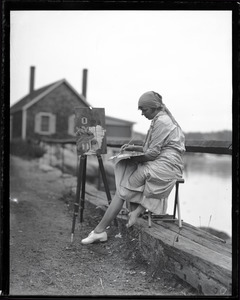 Juanita Hamel, painting at an easel on a pier