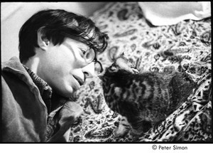 Ed Siegel playing with a cat on a bed