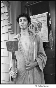 David Doubilet holding a shovel and standing in front of the Boston Herald Traveler front page reporting the Kent State Shooting