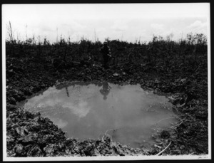 Soldier passing a water-filled crater