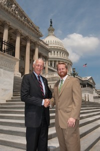 Congressman John W. Olver (center) shaking hands with unidentified man, posed on the steps of the United States Capitol building