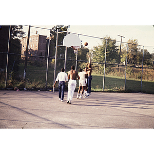 Young men playing basketball outdoors