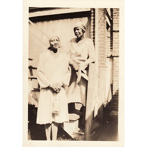 Two women pose on staircase