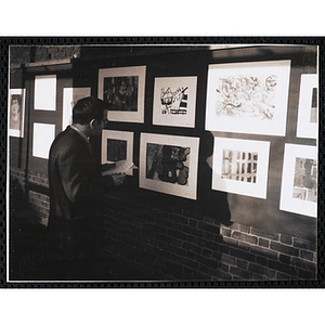 Art instructor Leon Moreau views the Boys' Clubs of Boston Tri-Club Art Exhibit at the Museum of Science