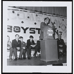 An unidentified man addresses an audience of children at a Boys' Club of Boston St. Patrick's Day inaugural ball and exercises event
