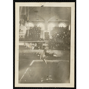A boy executes a dive as spectators look on at the Harvard University natorium