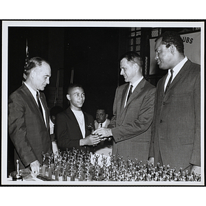 Richard Harte, Jr., at center, and two unidentified men presenting an award to a boy at a Kiwanis Club's awards ceremony