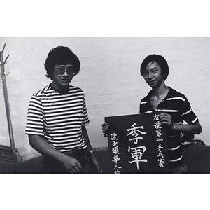 Young man and woman holding a sign