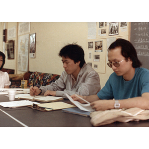 Two men and a woman seated at a table at a job placement class