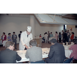 Chef stands at a table with a panel of judges