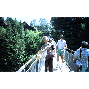 Woman stands on the Capilano Suspension Bridge in the temperate rain forest of British Columbia