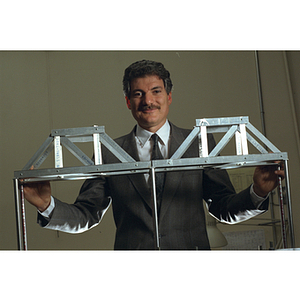 Mishac Yegian, a professor in the civil engineering department, standing behind a model