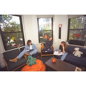 Students sit in a common area in a residence hall surrounded by Halloween decorations