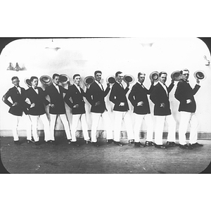 Nine students in costume stand in a line and wave their hats