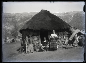 Man and woman in front of a hut