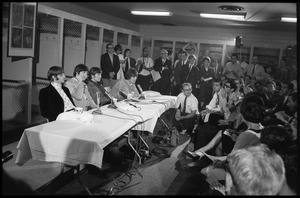 Ringo Starr, Paul McCartney, John Lennon, and George Harrison (l. to r.) seated at a table during a Beatles press conference