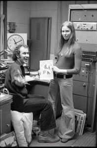 Richard Safft and unidentified woman with copy of Free Spirit Press magazine in radio broadcast studio