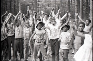 Inner City Round Table of Youth campers: group of African American children at summer camp, some wearing Spirit in Flesh t-shirts, raising hands and cheering