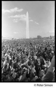 Massive crowd raising hands in peace symbols, with Washington Monument in background: Vietnam Moratorium march on Washington