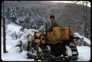 Tony Mathews on a tracked tractor, clearing snow, Montague Farm Commune