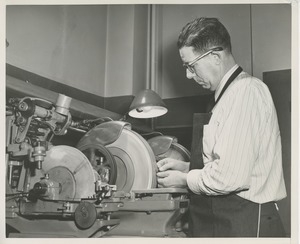 William Murphy working on optical lens grinding equipment