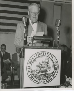 Bruce Barton speaking at a podium with the ICD logo