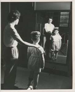 Physical therapist helping young boy with balance exercises