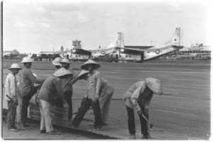 Views of aircraft on Tan Son Nhut airbase. Vietnamese laborers working on the base remove old pierced steel planking.