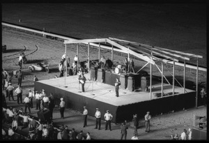 The Beatles performing at Suffolk Downs race track, police lined up in front of the stage